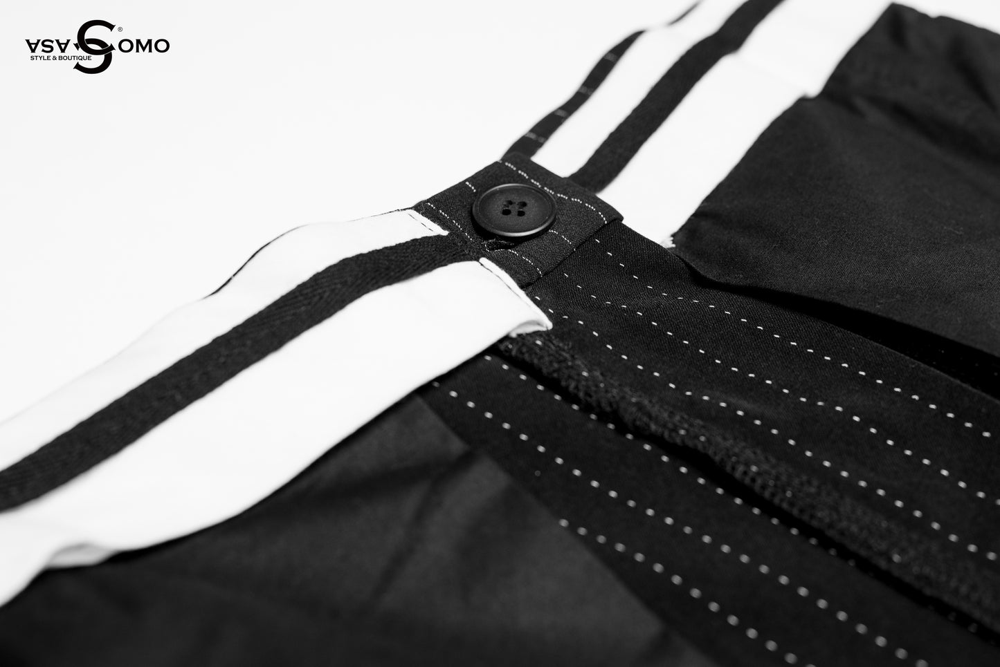 Model wearing black high-waisted pants with inside-out stitch details.