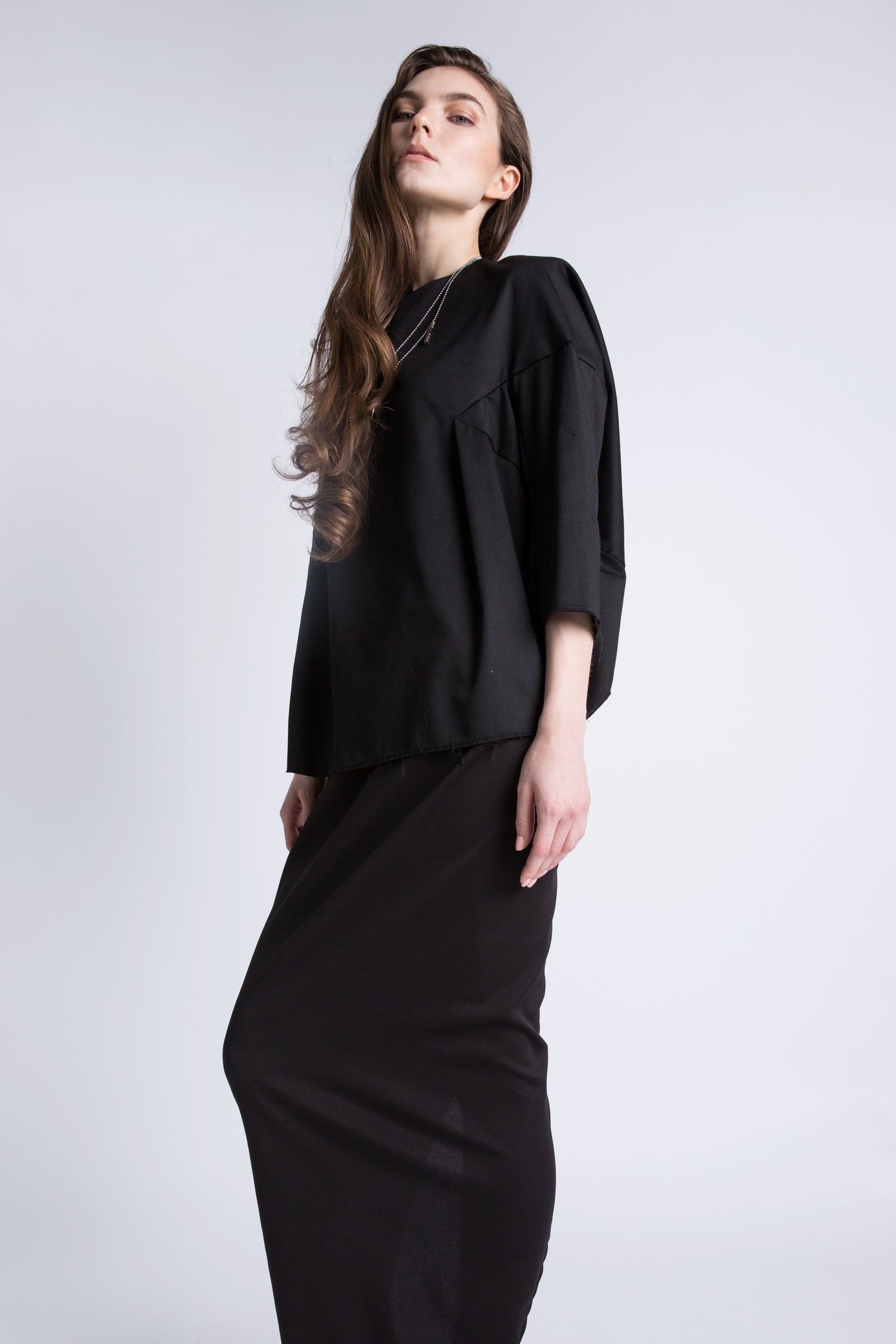 Model wearing high-waisted black pillar slit skirt, front view