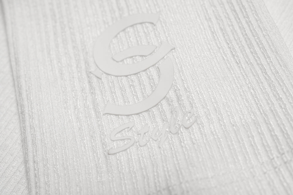 White bodysuit sleeve detail with 'C Style' logo close-up.