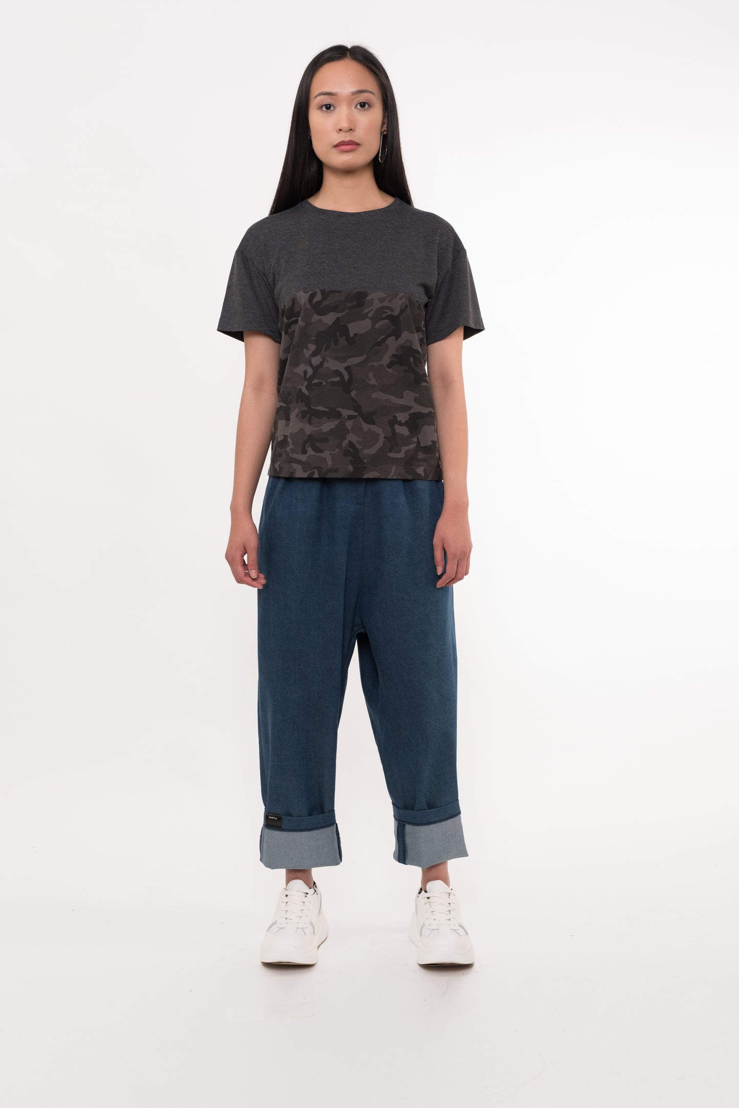 Model wearing camo and charcoal t-shirt with denim pants, front view