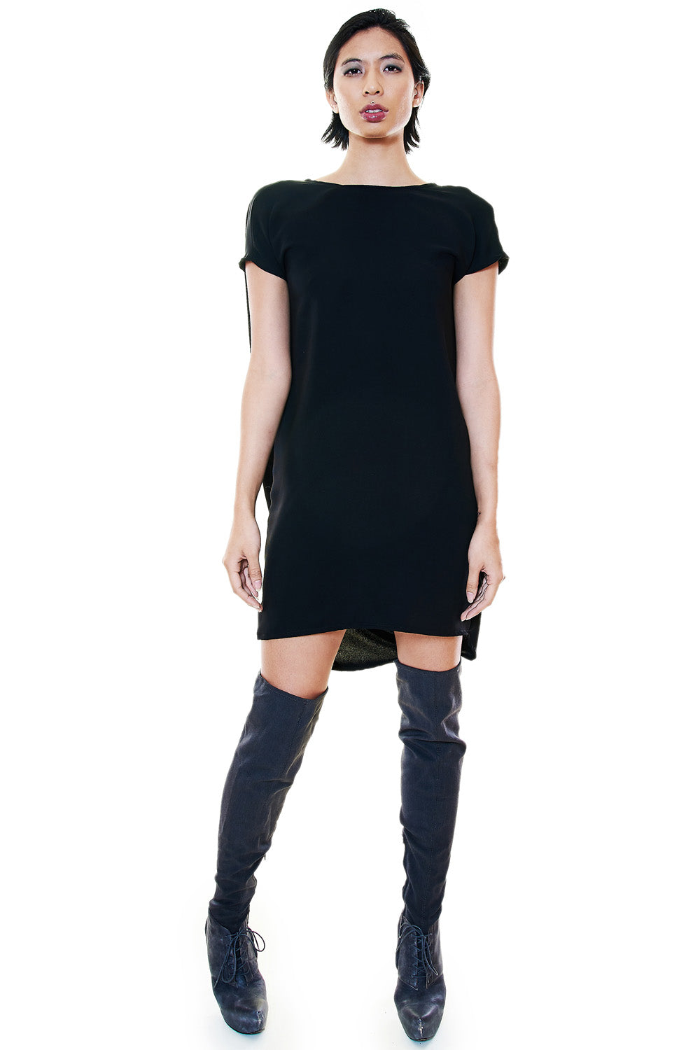Front view of a model wearing a black tunic dress with short sleeves.