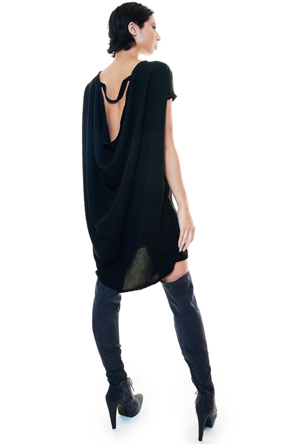 Back view of black tunic dress showcasing dramatic draped open-back detail