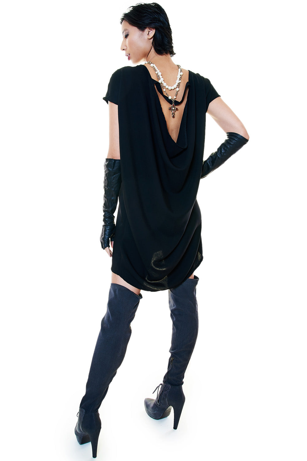 Styled black drape tunic with pearl necklace and gloves for an elevated evening look.