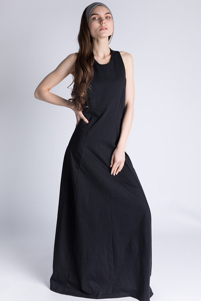 Model facing forward in black jersey racerback maxi dress, posing with confidence.