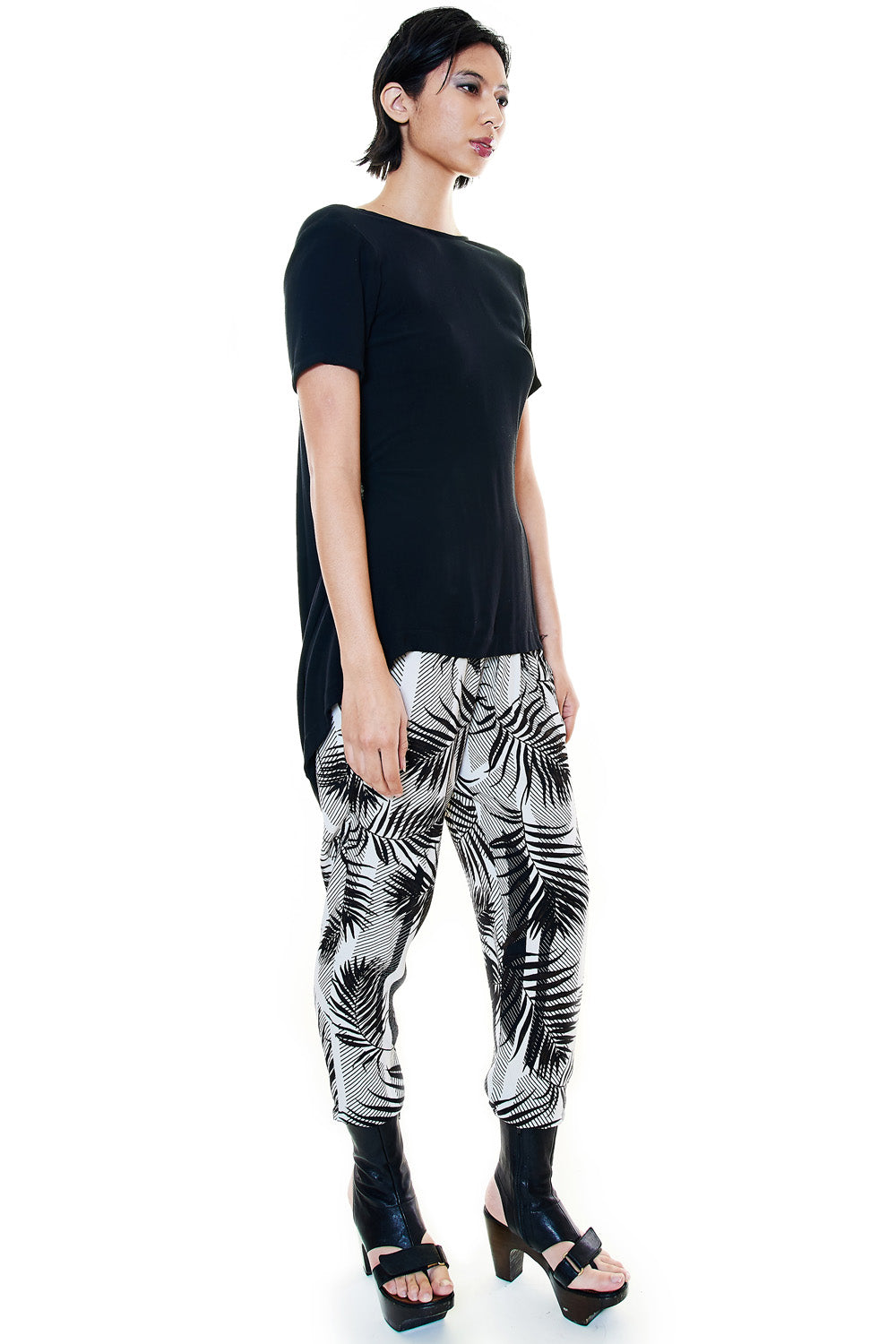 Woman modeling tropical palm print pants in side view
