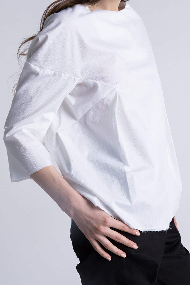 Side angle of blouse highlighting herringbone cotton texture