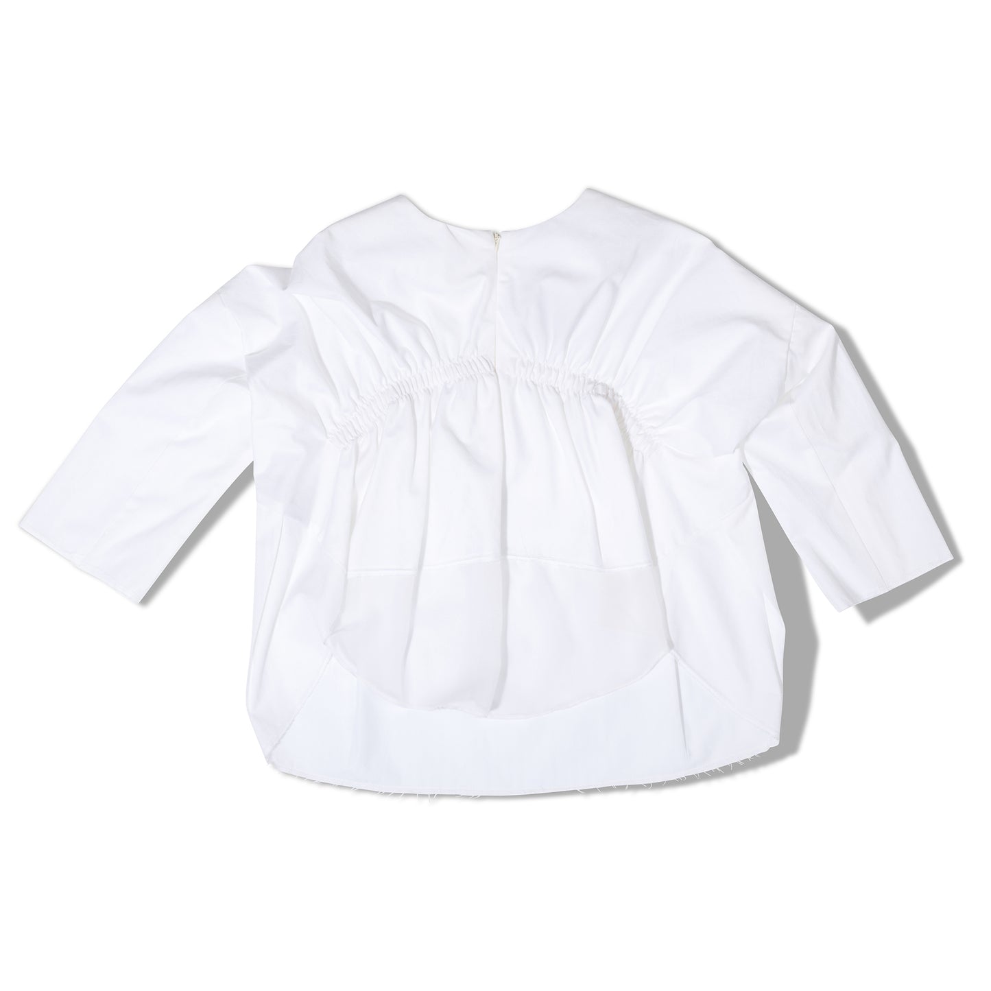 Studio flat lay of white blouse, back slit detail