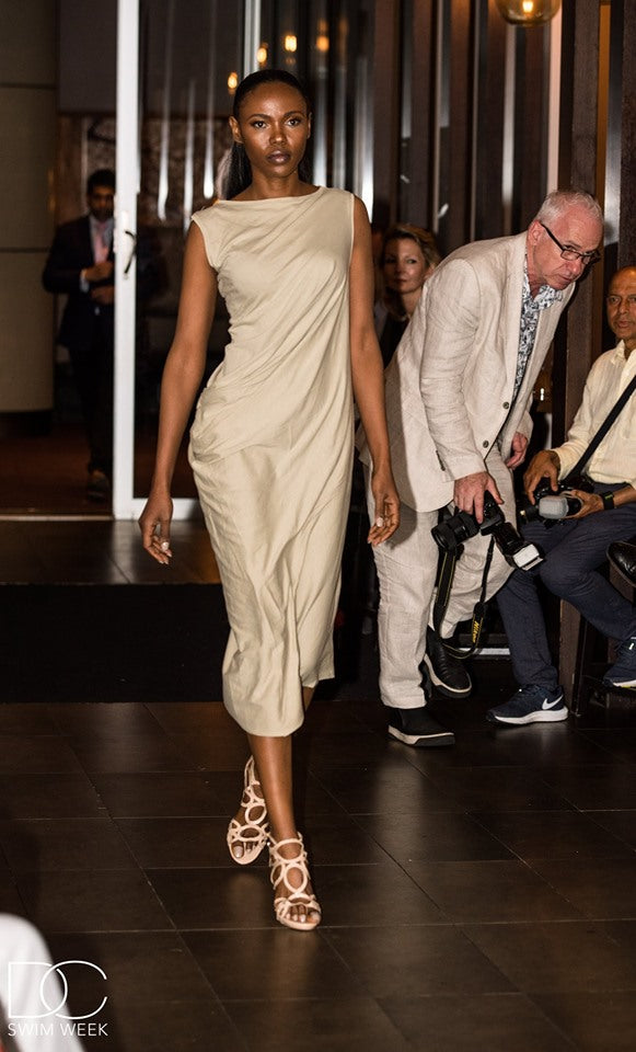 Front view of a beige draped midi dress, showcasing a chic asymmetrical design.