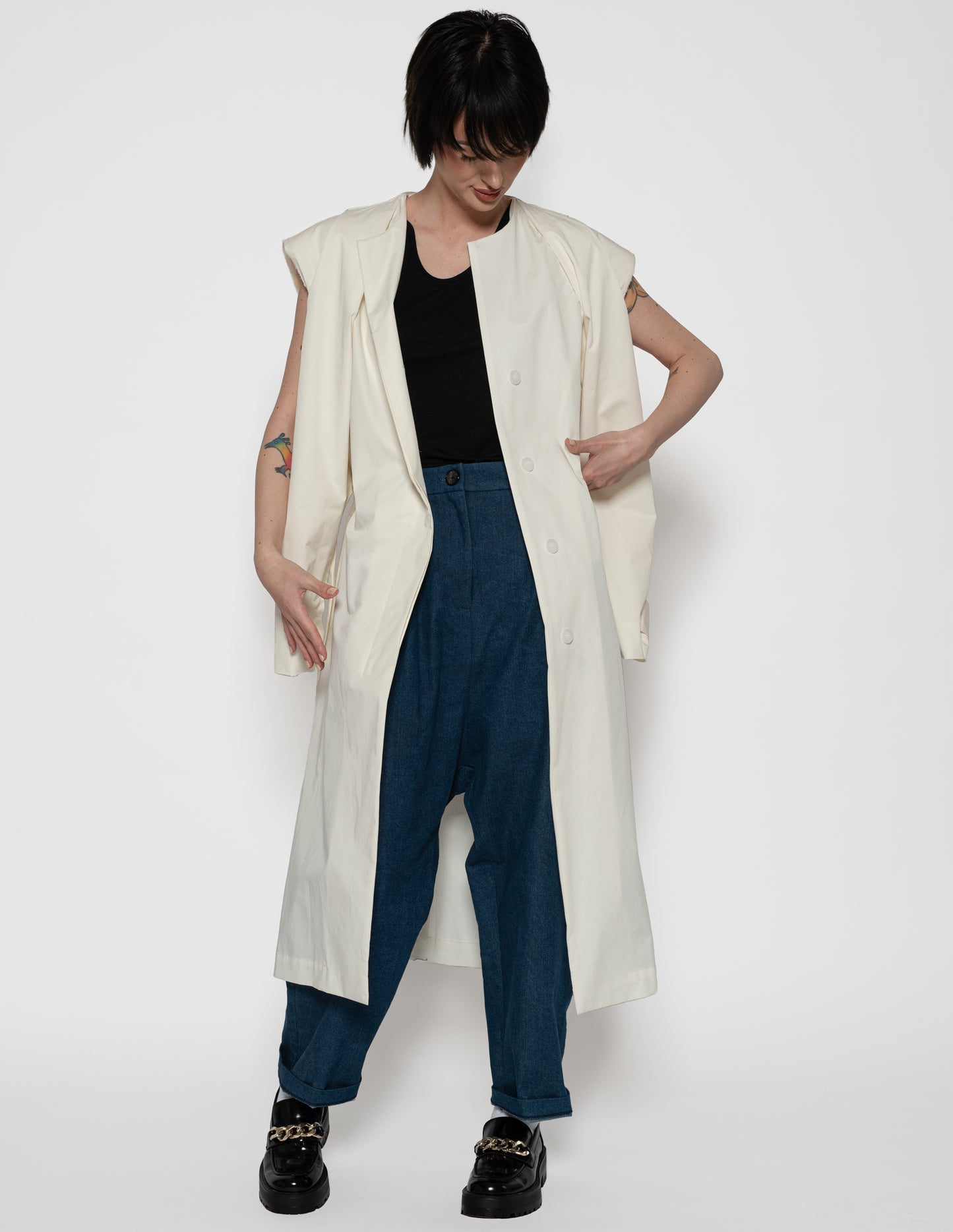 Unisex convertible trench coat in motion showing layered back panel and sleeveless cut.