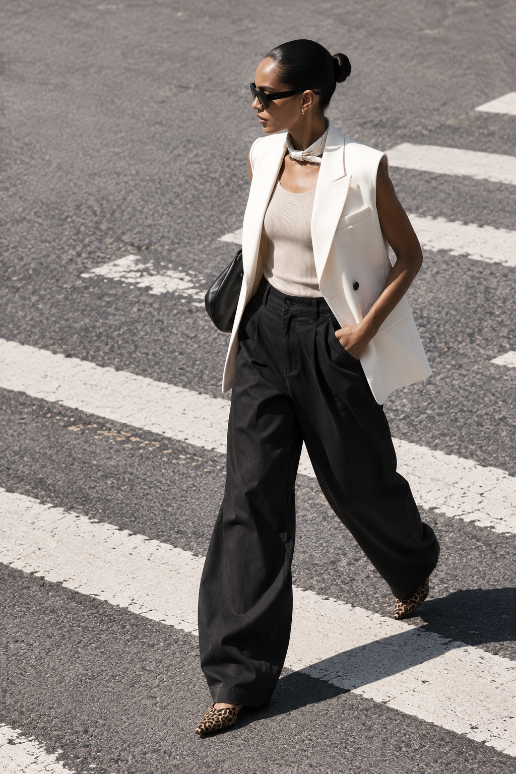 Model wearing Casa Como ivory tailored vest with relaxed black trousers in a street-style look.