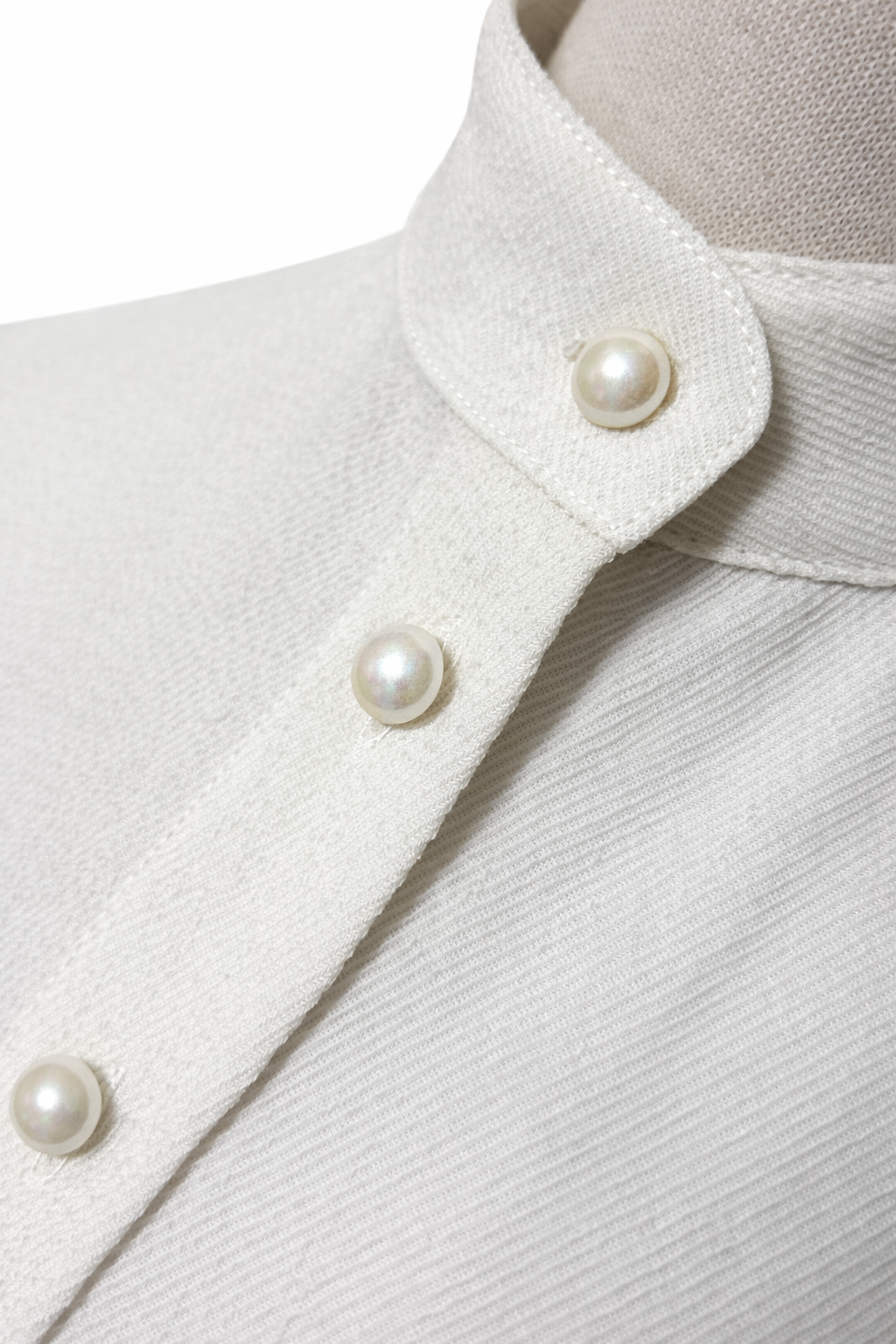 Close-up of genuine mother-of-pearl buttons on ivory blouse
