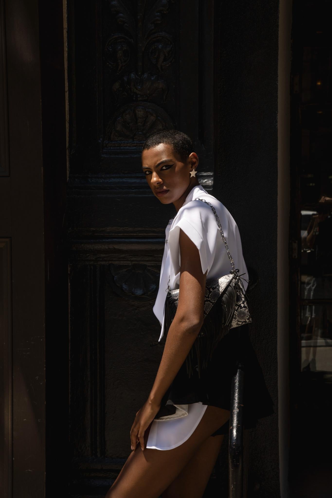 Side view of model in black asymmetric flare shorts