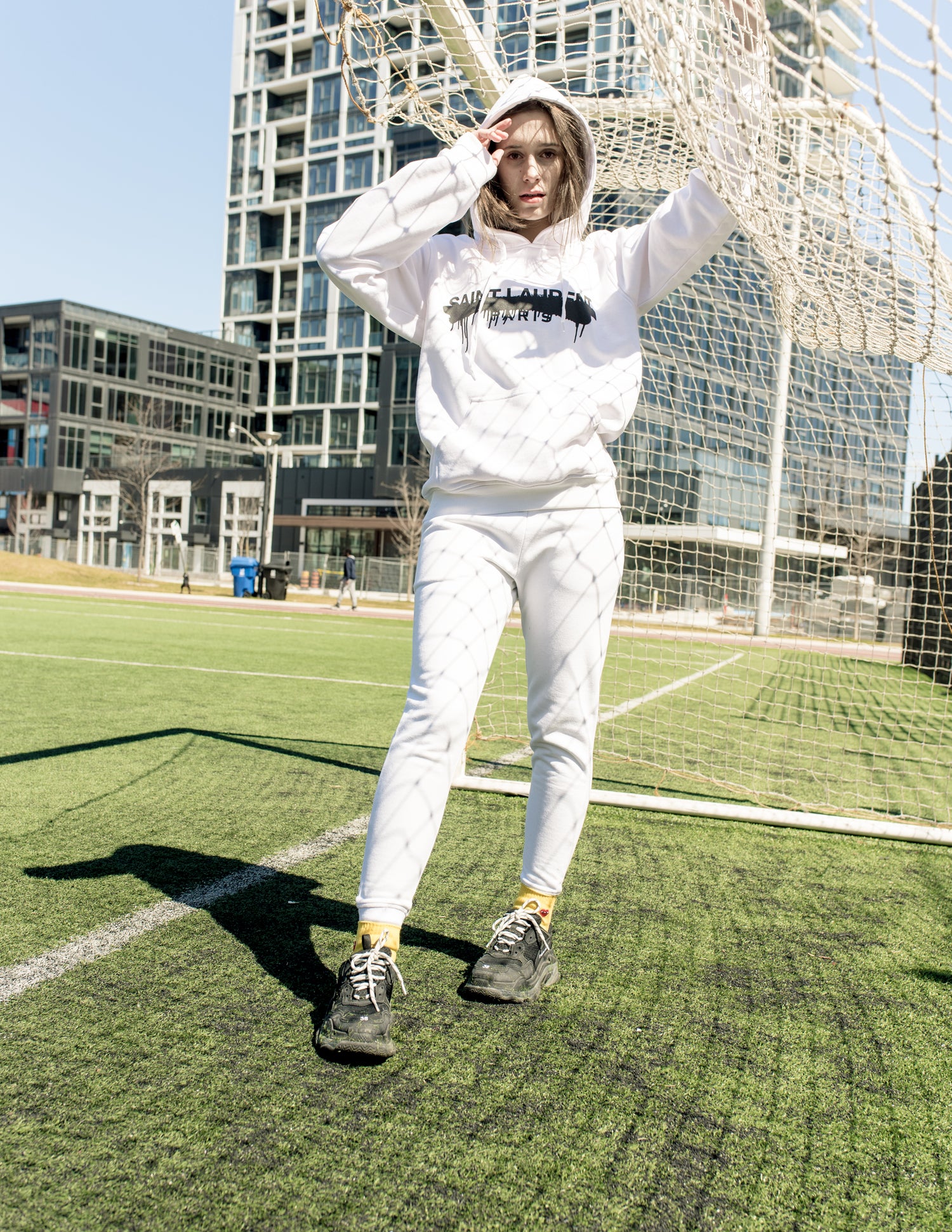 White hoodie with black graphic print styled streetwear look – urban backdrop